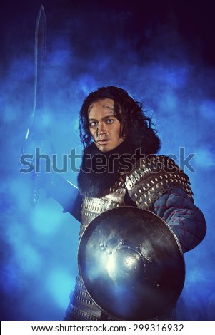 Ancient male warrior in armor holding sword. Historical character. Fantasy.
