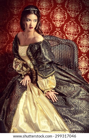 Full length portrait of a beautiful elegant lady in the lush expensive dress posing over vintage background. Renaissance. Barocco. Fashion.