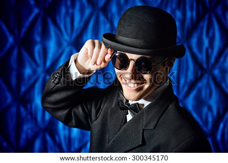 Portrait of an elegant old-fashioned artist man wearing black suit and bowler-hat. Fashion, style. Cinema, theater.