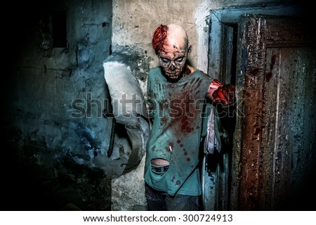 Horrible scary zombie man on the ruins of an old house. Horror. Halloween.