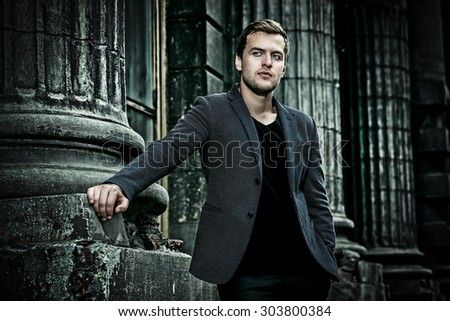 Handsome elegant man posing on a city street. Fashion shot. Business man outdoor.