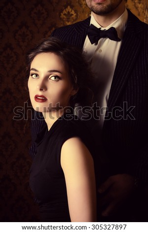 Beautiful man and woman in elegant evening clothes in classic vintage apartments. Glamour, fashion. Love concept.