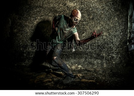 Horrible scary zombie man on the ruins of an old house. Horror. Halloween.