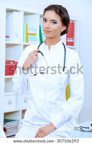 Smiling female doctor in white coat looking at camera. Medicine, healthcare.