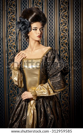 Baroque Style - beautiful young woman in elegant historical dress and with barocco hairstyle posing over vintage background. Renaissance. Barocco. Fashion.