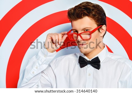 Elegant handsome man posing by a red shooting target. Spy man. Beauty, fashion.