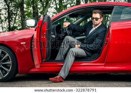 Handsome young man in his new sports car.
