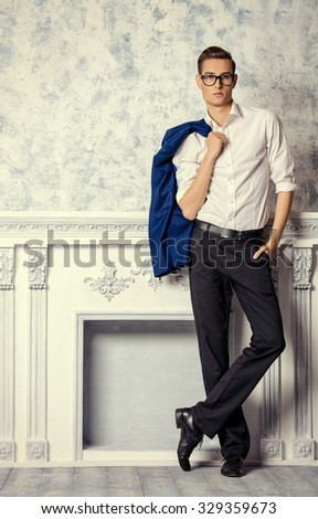 Vogue shot of a handsome elegant man in a suit posing in vintage interior. Men's beauty, fashion.