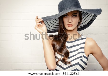 Portrait of a beautiful graceful woman in elegant hat with a wide brim. Beauty, fashion concept.
