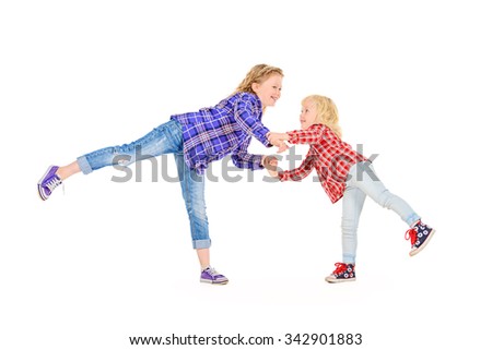 Older and younger sisters playing together and laughing. Happy childhood. Family concept. Isolated over white.