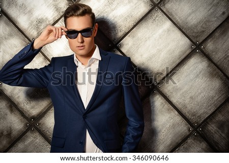 Close-up portrait of a handsome man in elegant classic suit and sunglasses. Men\'s beauty, fashion.