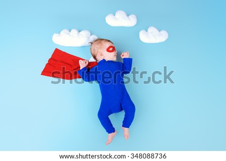 Newborn baby. Little super hero flying through the sky.