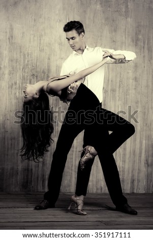 Black-and-white portrait of a beautiful young couple dancing tango with passion. Professional dancers. Latino dancers.