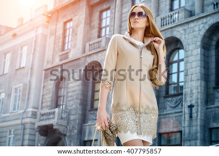 Beautiful fashionable woman walking on the city street. Elegant businesswoman outdoor.