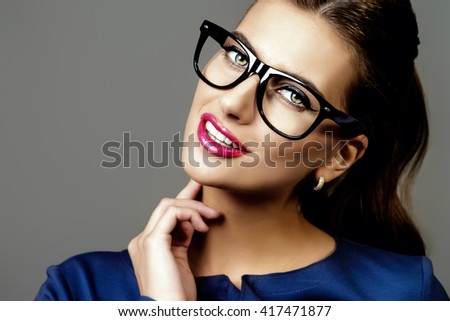 Optics style. Portrait of a beautiful young woman wearing elegant glasses. Beauty, fashion. Cosmetics, make-up.