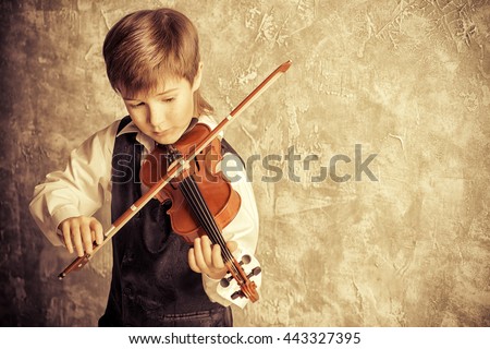 Freckled nine year old boy playing the violin. Musical education. Inspiration.