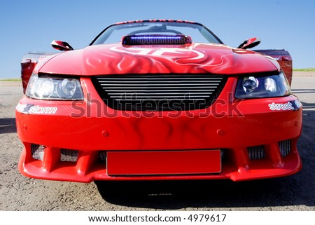 Sport red car with polished chrome trim.