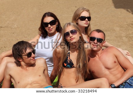 Cheerful young people having fun on a beach. Great summer holidays.