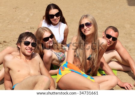 Cheerful young people having fun on a beach. Great summer holidays.