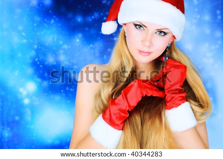 Portrait of a naked young woman wearing christmas cap and red gloves over sky of stars and snow.