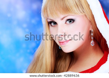 Portrait of a beautiful young woman wearing christmas clothes over sky of stars and snow.