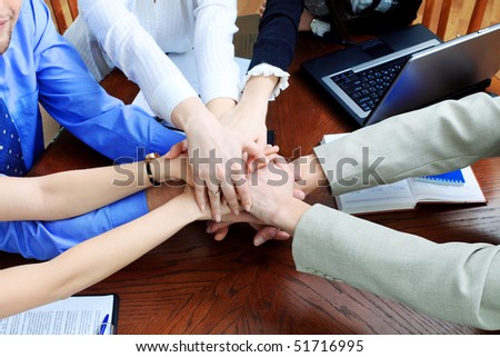 Business theme: hands on top of each other.