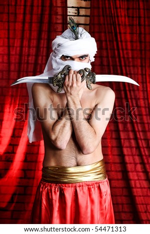 Shot of a man in oriental costume holding daggers.