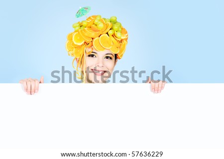 Shot of a beautiful young woman with fruits headwear holding white board. Food concept, healthcare.