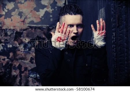 Shot of a scary man with bloody hands,  gothic style. Halloween, horror.