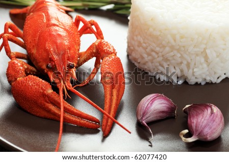 A dish with steamed white rice and boiled crawfish.