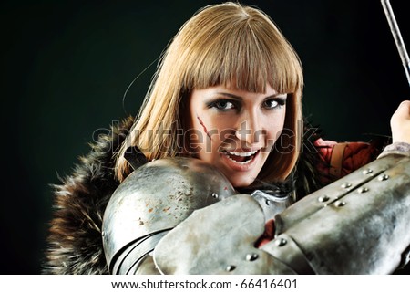 Portrait of a medieval female knight in armour over black background.
