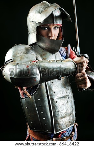 Portrait of a medieval female knight in armour over black background.