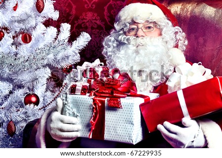 Santa Claus with presents and New Year tree at home. Christmas.