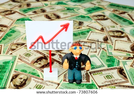 Shot of a plasticine businessman in a suit. Over money background.