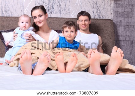 Happy family in bed under cover.
