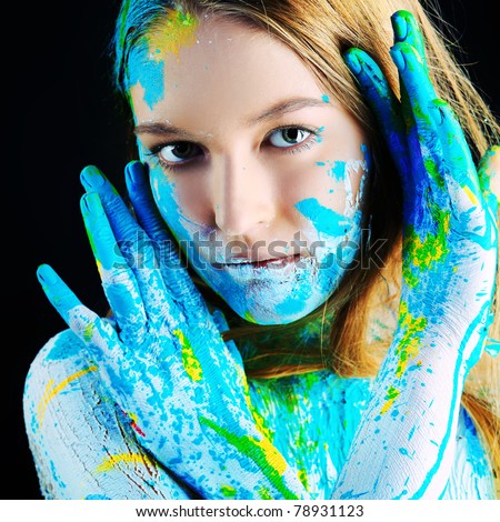 Art project: beautiful woman painted with many vivid colors. Over black background.