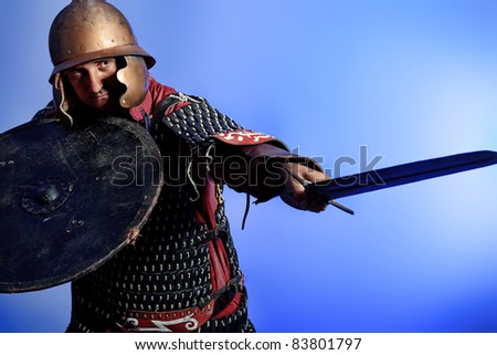 Portrait of a medieval male knight in armor over blue background.