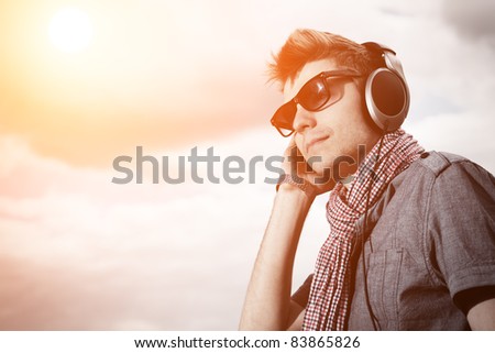 Portrait of a handsome young man in headphones posing outdoor.