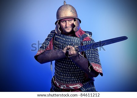 Portrait of a medieval male knight in armor over blue background.