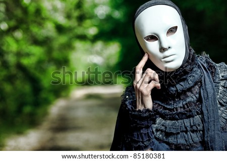 Shot of a woman in mask wearing old-fashioned dress.