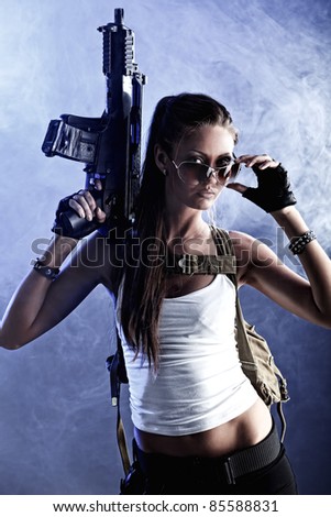 Shot of a sexy military woman posing with guns.