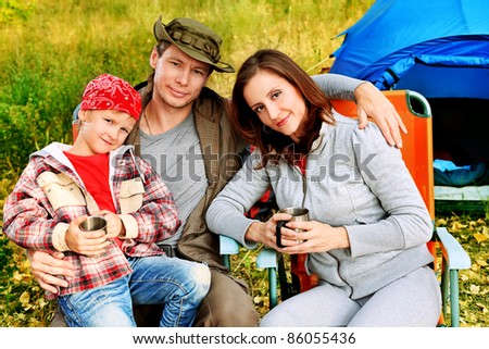 Happy family having a rest outdoor in tent.