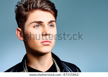Studio shot of a handsome young man over gray background.
