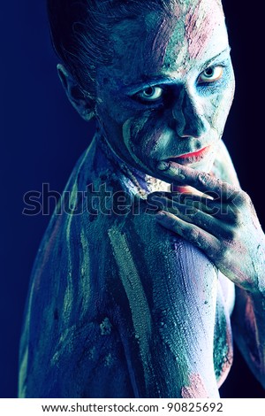 Portrait of an artistic woman painted with clay. Shot in a studio.