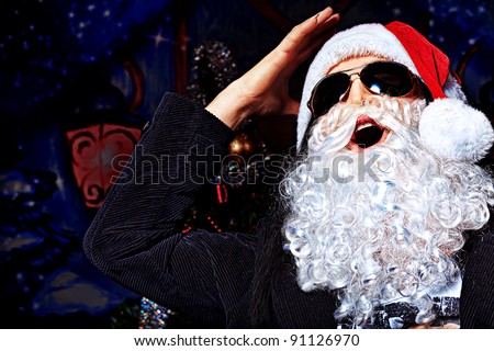 Portrait of a funny young man in Santa Claus costume making faces. Christmas.