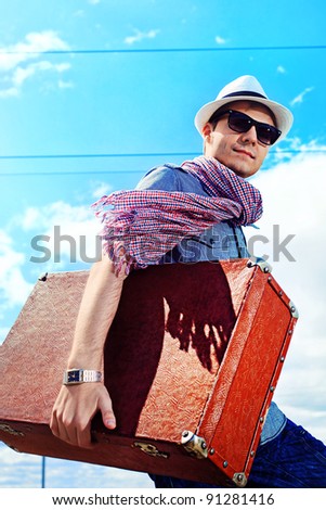 Handsome young man walking along railroad.