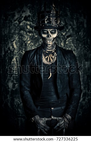 A man with a skull makeup dressed in a tail-coat and a top-hat. Baron Saturday. Baron Samedi. Dia de los muertos. Day of The Dead. Halloween.
