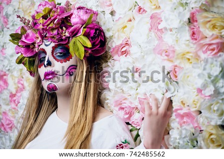 Dia de los muertos. Day of The Dead. Woman with sugar skull makeup on a floral background. Calavera Catrina. Halloween.