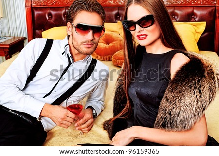 Portrait of a handsome fashionable man with  charming woman posing in the interior.