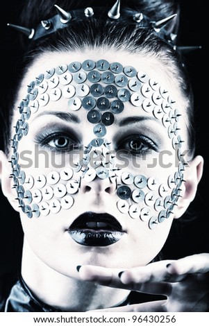 Conceptual shot of a woman with metal buttons on her face.